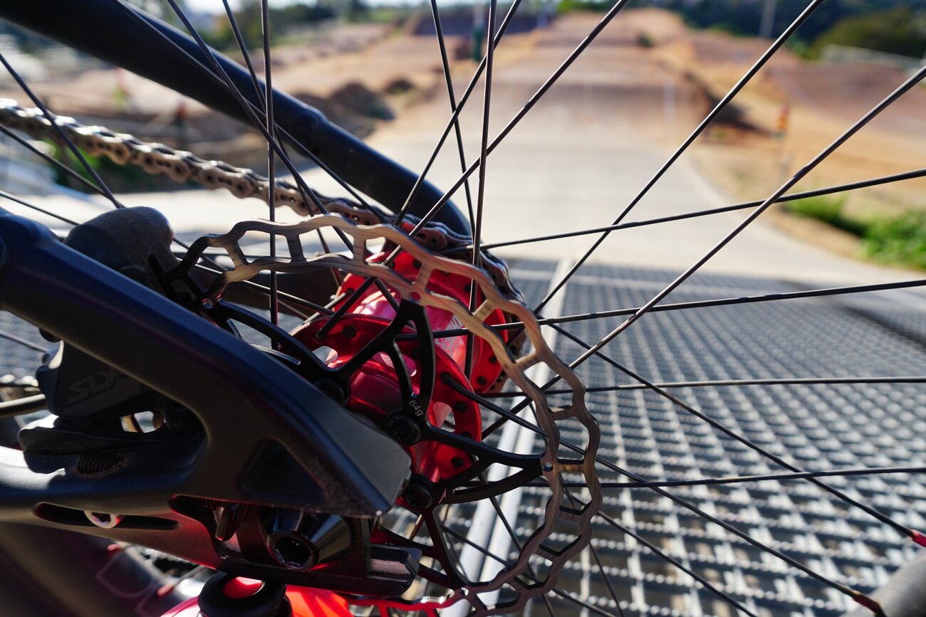 Close-up of a BMX race bike drivetrain and 20 inch wheel on the start grid